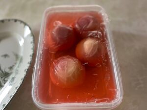 保存容器にいれ、ラップで落し蓋をした桃の写真（一晩冷蔵庫で冷やした状態）