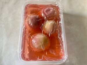 保存容器にいれ、ラップで落し蓋をした桃の写真