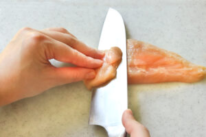 鶏肉を削ぎ切りにする様子