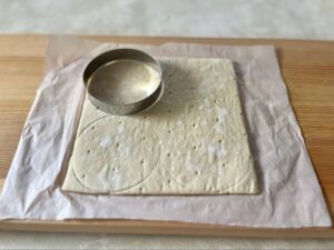 パイ生地を9cmのセルクルで抜く様子