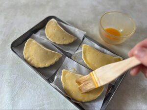 焼く前のパイ生地に卵を塗る様子