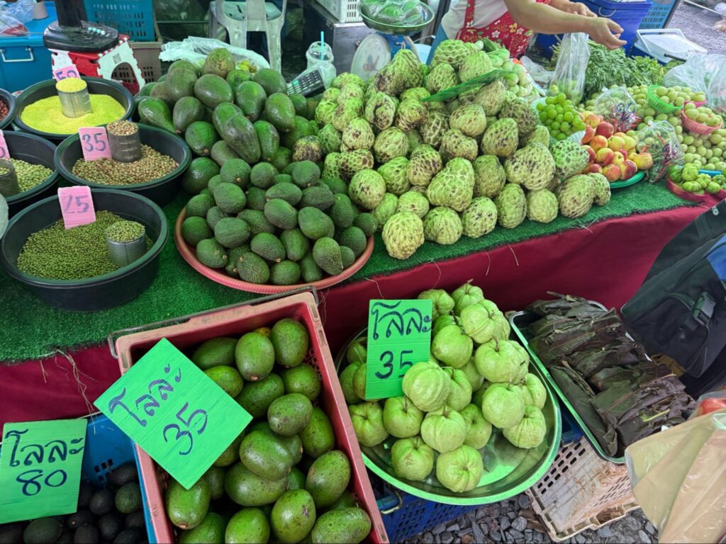 店先で山積みのアテモヤが売られている様子（チェンマイ雲南マーケット）