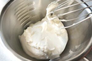 ボウルに角が立つ程度に泡立てられた生クリームが入っている写真