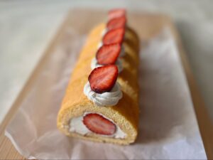 まな板に乗ったいちごとホワイトチョコのロールケーキ（5カット分）