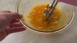 ボウルに入れた卵をハンドミキサーで混ぜる写真