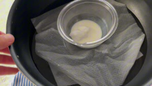 湯せん用のお湯に、ココナッツオイルと牛乳を合わせた小皿が入っている写真