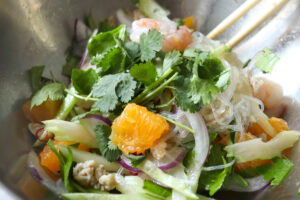 混ざった材料が入ったボウルにパクチーを追加した様子