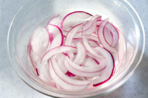 薄切りの紫玉ねぎを水にさらしている様子