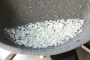 油とみじん切りにしたニンニクを油でいためる様子