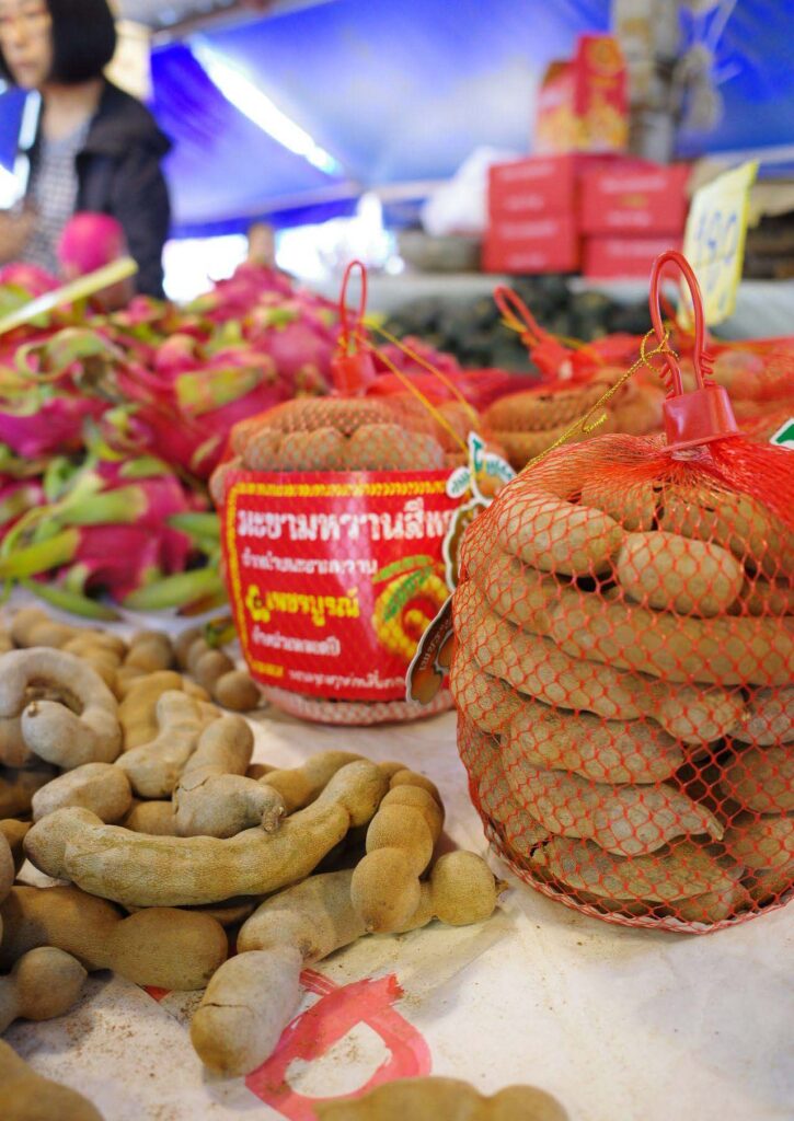 タイの市場でネットいっぱいに詰めて販売されているタマリンドの写真