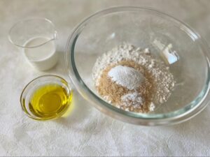 粉類の材料(小麦粉2種、きび砂糖、塩、ベーキングパウダー)をすべていれたボウルの写真
