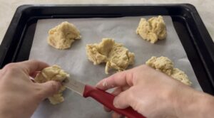 生地をパン切り包丁で半分に切る様子