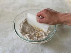 ボウルの周囲や底をカードでこそぐ様子