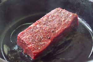 フライパンで牛ブロックを焼く様子