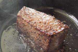 フライパンで牛ブロックを焼く様子