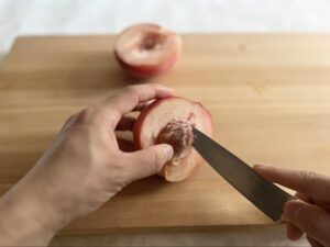 包丁で桃の種をとる様子